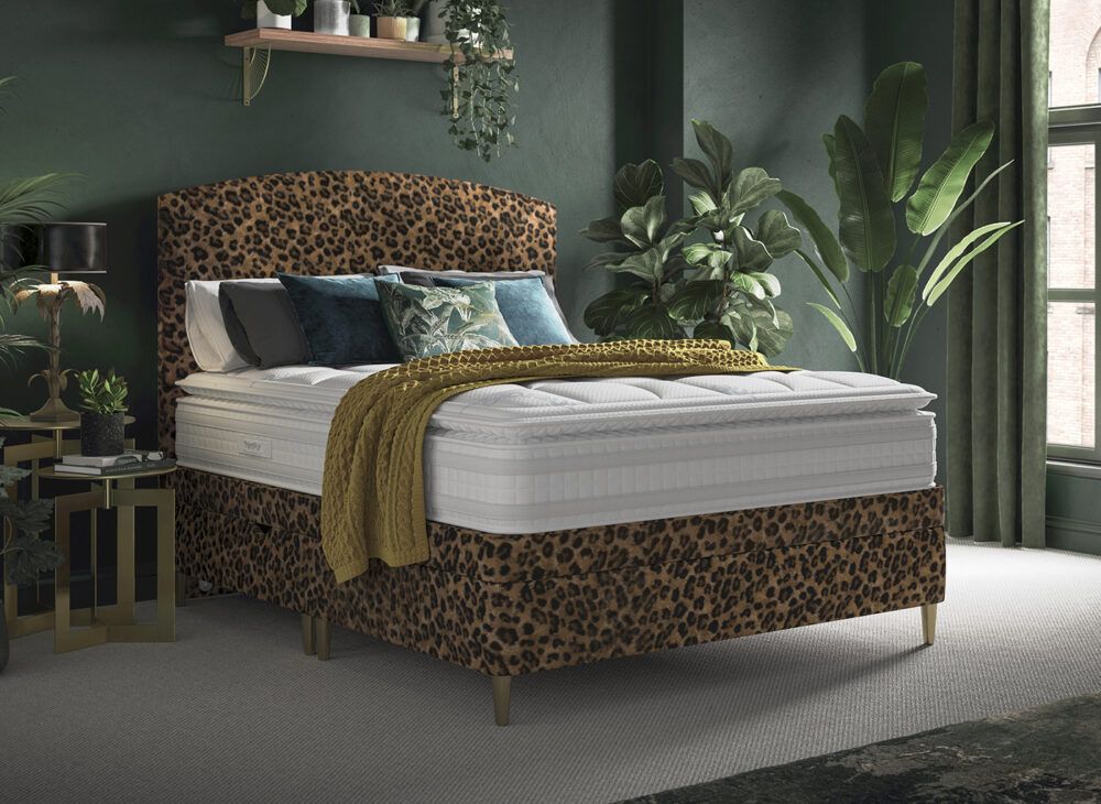 Animal print bedroom decor ideas - Leopard print headboard and divan base in a green bedroom with plants