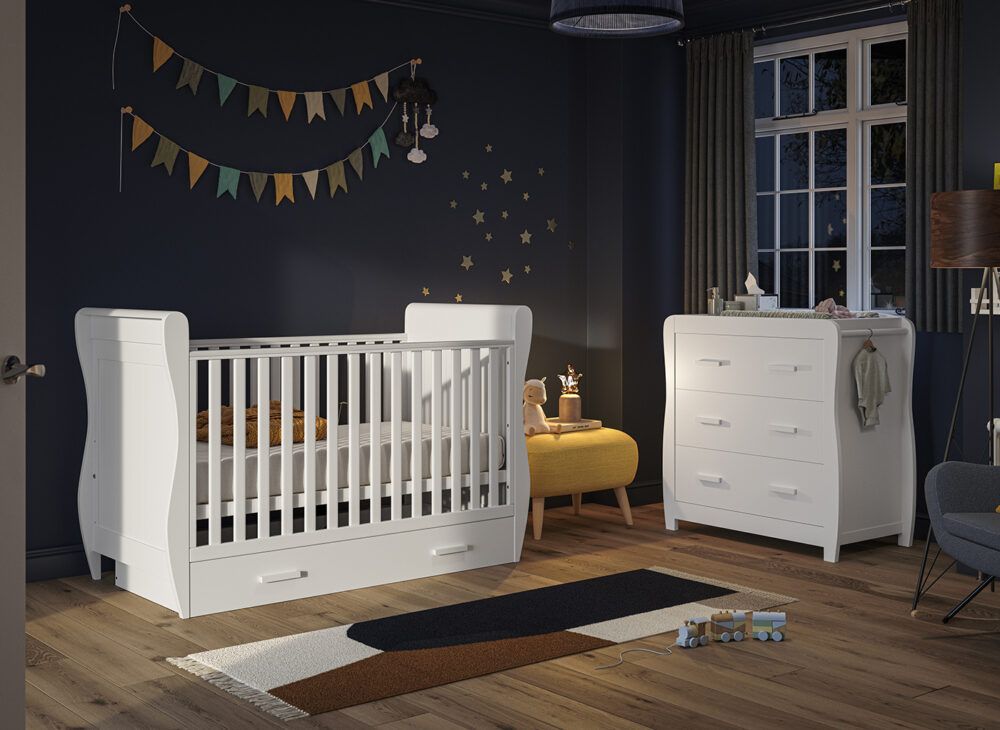 Nursery ideas to welcome your baby into the world - A white cot and 2-in-1 chest and changing station, dressed in dark cosy nursery with wall decor.
