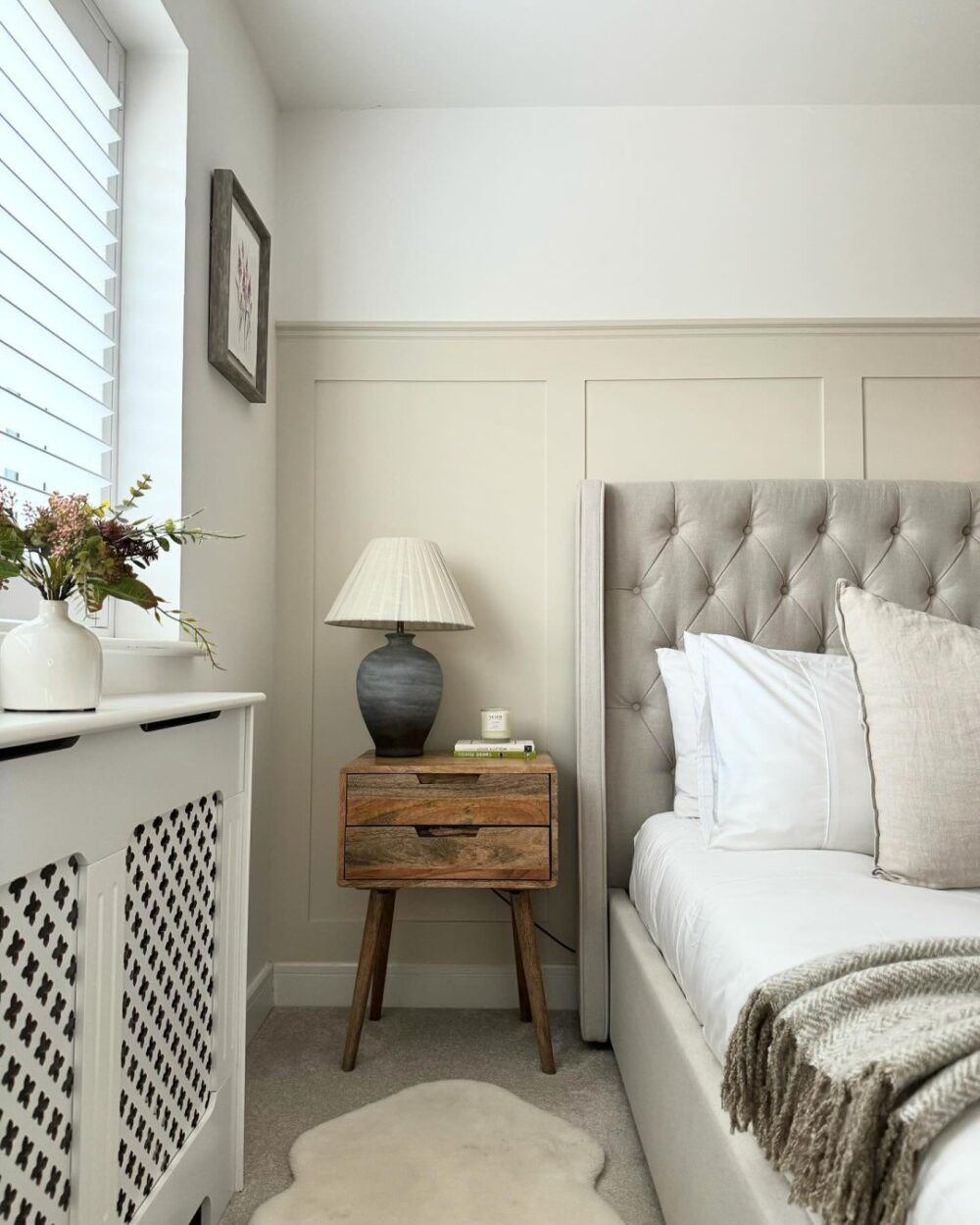 Beige buttoned bed frame, styled with a vintage bedside table and white neutral accents - Bedroom layout ideas
