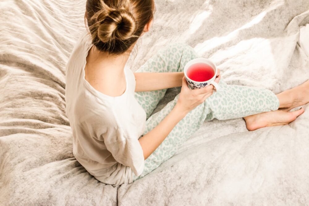 Woman drinking natural tea in bed