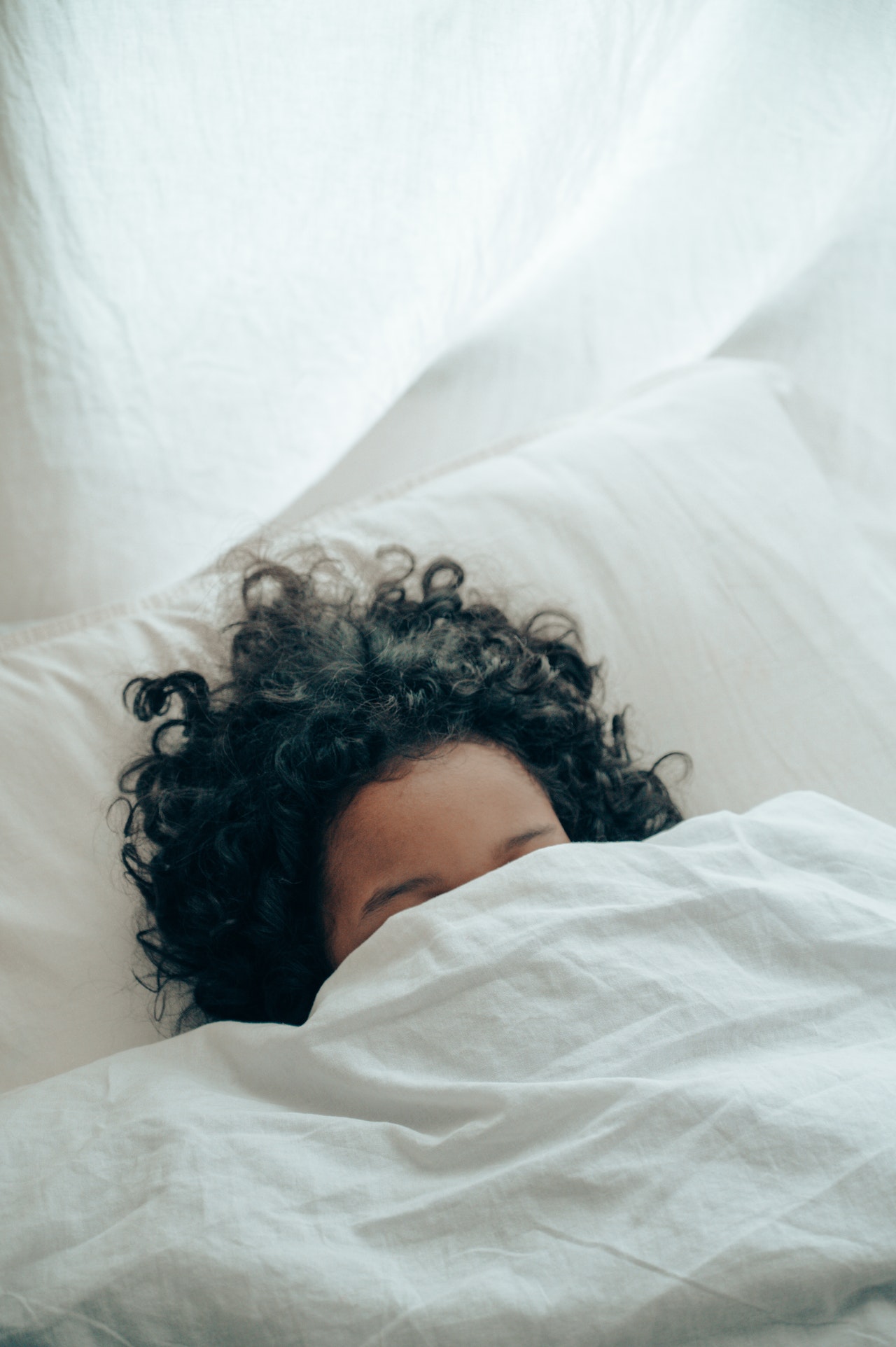Lady with head under the covers