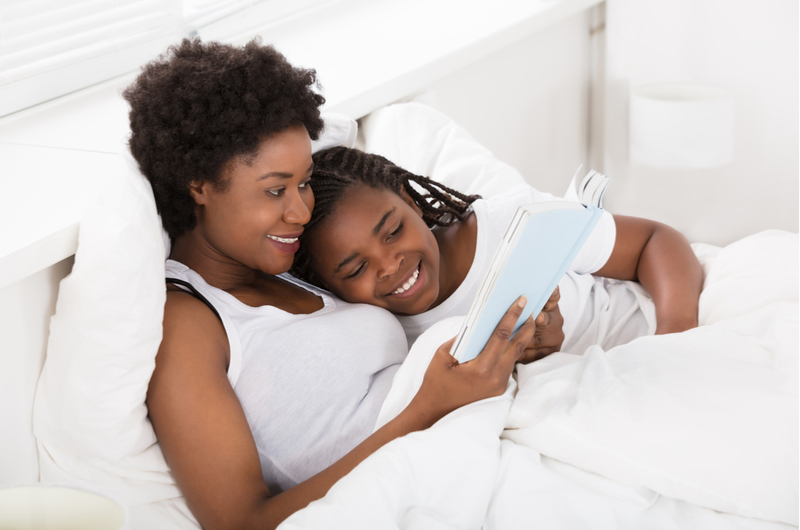 Woman and child reading in bed
