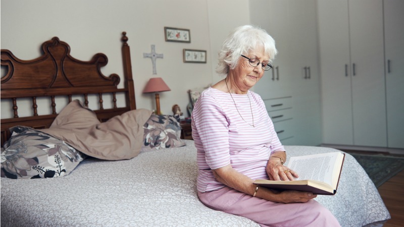 Old lady reading on bed